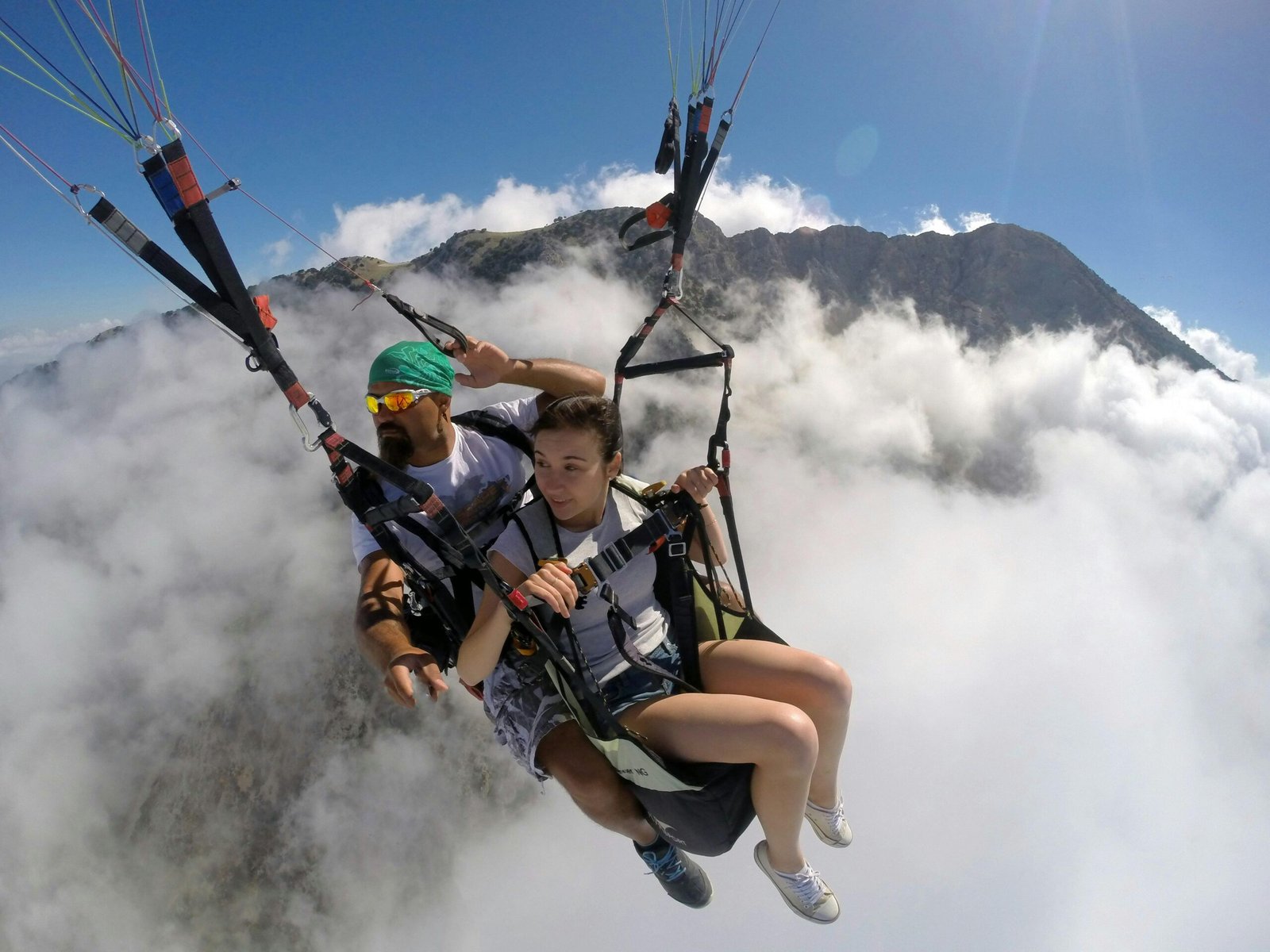 Experience the thrill of tandem paragliding above the stunning mountains of Turkey on a clear day.